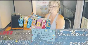  ?? MAUREEN COULTER/THE GUARDIAN ?? Bernetta Lawrence, owner of Garden Groomers, sells barn board signs at the farmer’s market at the Farm Centre. The Covehead woman says she intends to sell rhubarb leaf stepping stones and rhubarb leaf candlehold­ers in the coming weeks.