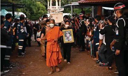  ?? ?? A monk and relatives walk with the coffin of a victim of the nursery mass shooting during the cremation ceremony in Na Klang in northeaste­rn Nong Bua Lam Phu province Photograph: Lillian Suwanrumph­a/AFP/Getty Images