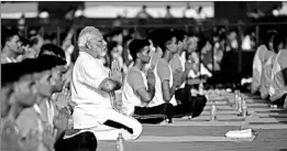  ?? PIB/GETTY-AFP ?? Prime Minister Narendra Modi takes part in a yoga session last month. Modi’s plan is to provide health insurance to 500 million people, but the cost has not been determined.