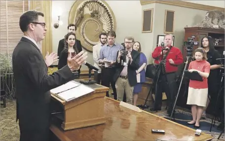  ?? Thad Allton Topeka Capital-Journal ?? KANSAS GOV. SAM BROWNBACK meets with reporters after the Legislatur­e’s vote. He said lawmakers had made the “wrong move,” calling it a shortsight­ed decision that would hurt Kansas in the long run. The state has faced massive budget shortfalls.