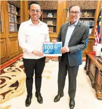  ?? ?? Milestone event: Sim (left) presenting an update on his first 100 days in office as hr Minister to Prime Minister datuk Seri anwar Ibrahim.