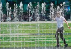  ?? — AFP ?? A girl cools off in a public fountain in Berlin.