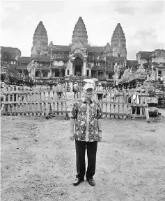  ??  ?? Minos stands in front of the Angkor Wat during a recent visit