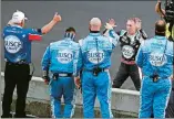  ?? DARRON CUMMINGS/AP PHOTO ?? Kevin Harvick, on far side of wall, celebrates with his crew after winning the NASCAR Cup race at Indianapol­is Motor Speedway on Sunday.