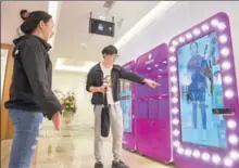  ?? SU YANG / FOR CHINA DAILY ?? Two customers try a virtual fitting room at a department store in Nanjing, capital of Jiangsu province.