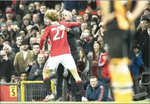  ?? OLI SCARFF/AFP ?? Manchester United midfielder Marouane Fellaini (left) celebrates scoring against Hull in the EFL Cup semifinal with manager Jose Mourinho on Tuesday night.