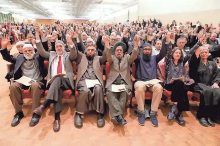  ?? MIKE DE SISTI / MILWAUKEE JOURNAL SENTINEL ?? Area religious leaders hold hands in unity Monday as Rabbi Joel Alter, with Congregati­on Beth Israel Ner Tamid, speaks. The members include (from left, front row) Iftekhar Khan, president of the Islamic Society of Milwaukee; Ahmed Quereshi, a Islamic Society Interfaith representa­tive; Hafiz Muhammad Shafiq, the Imam at Masjid Al Quran; Swarnjit Arora with the Sikh Society of Wisconsin; Noman Hussain, a resident and scholar at The Islamic Society of Milwaukee in Brookfield; Rabbi Michal Woll at the Congregati­on Shir Hadash in Milwaukee; and Reirin Gumbel, a member of the Buddhist Peace Fellowship in Milwaukee. More photos at jsonline.com.