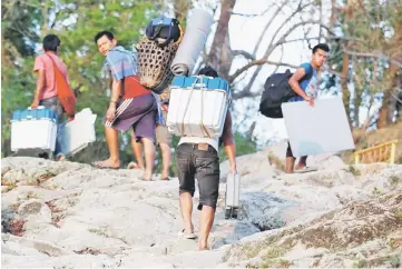  ??  ?? Porters carry Voter Verifiable Paper Audit Trail (VVPAT) machines and an Electronic Voting Machines (EVM) through Buxa tiger reserve forest to a remote polling station, in Alipurduar district in the eastern state of West Bengal, India.