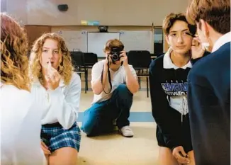  ?? ?? Stephen Richardson takes a photo of Julia Stratton, right, and Nina Fuller in their school band room at Ravenna High School. For the kids who call it home, the band room is a place of real refuge: somewhere to go during free periods, if you don’t like your lunch or if you just need a few minutes to reset your day.