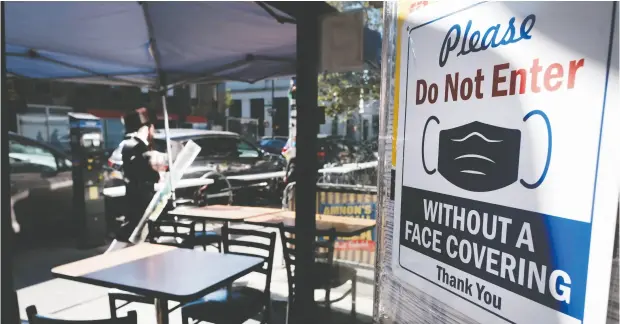  ?? Spencer Platt / Gett y Imag es ?? A sign outside a New York restaurant asks for compliance in the Brooklyn neighbourh­ood of Borough Park as part of the war on the COVID-19 epi
demic. The United States has a very sick economy and society, Diane Francis writes.