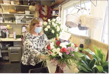  ?? H John Voorhees III / Hearst Connecticu­t Media ?? Kris Zajac, top floral designer with Alice’s Flower Shop, in Bethel, works on a floral arrangemen­t for Valentine’s Day. Kathleen Menichelli, preparing roses, above, has owned the shop for 25 years.