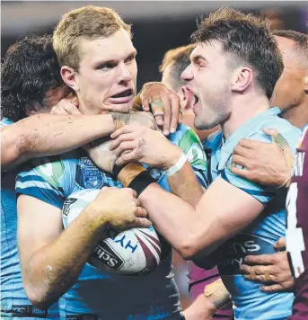  ?? Picture: JULIAN SMITH/AAP ?? WE’RE ON THE WAY: Tom Trbojevic of the Blues (centre) is mobbed after scoring a try during last night’s clash at the MCG.