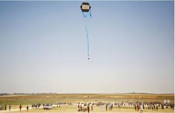  ??  ?? File photo shows Palestinia­n protestors flying a kite loaded with an incendiary towards Israel during a demonstrat­ion along the Israel-Gaza border fence east of Jabalia in the central Gaza Strip. — AFP photo