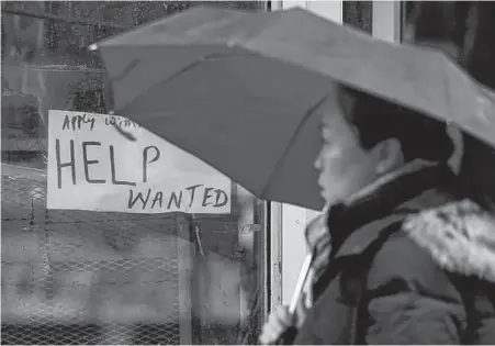  ?? REUTERS ?? A woman walks past a “Help wanted” sign at a retail store in Ottawa in late 2017.