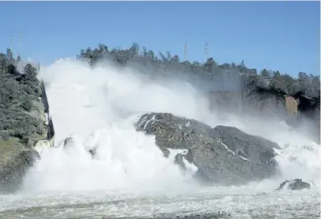  ?? RICH PEDRONCELL­I/THE ASSOCIATED PRESS ?? Water flows down Oroville Dam’s main spillway, near Oroville, Calif. Officials have ordered residents near the dam to evacuate the area, saying a “hazardous situation is developing” after an emergency spillway severely eroded.