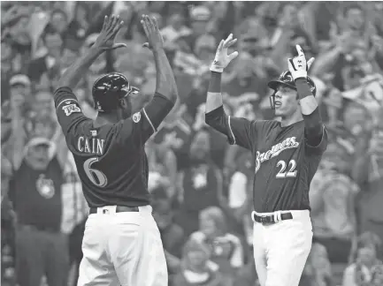  ??  ?? Christian Yelich celebrates with Lorenzo Cain after hitting a two-run home run against the Rockies in the third inning in Game 1 of the NLDS at Miller Park. BENNY SIEU/USA TODAY SPORTS