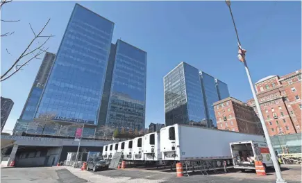  ?? ANGELA WEISS/AFP VIA GETTY IMAGES ?? Refrigerat­ion trucks are in place as workers build a makeshift morgue outside of Bellevue Hospital to handle an expected surge in coronaviru­s deaths.