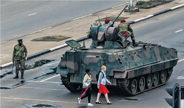  ??  ?? Zimbabwean troops stand guard in the streets of Harare as residents of the capital try to go about their business. The army detained President Robert Mugabe, below, in an effort to thwart the rise to power of his wife, Grace