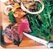  ?? KATIE WORKMAN VIA THE ASSOCIATED PRESS ?? Grilled lamb chops and onions with herb salad.