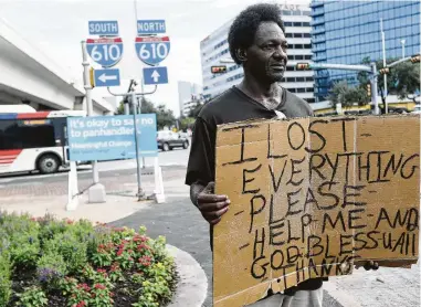  ?? Elizabeth Conley / Staff photograph­er ?? Tyron Davis panhandles near 610 and Westheimer despite a sign asking people not to give money.