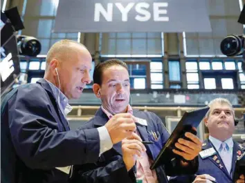  ??  ?? Traders work on the floor at the New York Stock Exchange (NYSE) in New York, US.