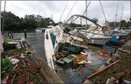  ?? The Associated Press ?? DEBRIS:
A sinking boat is surrounded by debris in the aftermath of Hurricane Irma on Monday at Sundance Marine in Palm Shores, Fla.