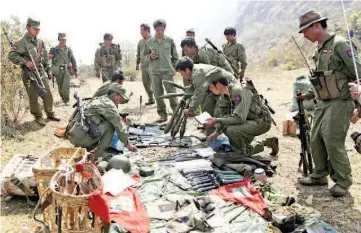  ??  ?? File picture shows rebel soldiers of the Myanmar National Democratic Alliance Army (MNDAA) examine weapons and ammunition at a military base in Kokang region. — Reuters photo