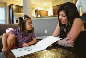  ?? Brett Coomer photos / Houston Chronicle ?? Miranda reads with her mother, Karina Pichardo, at their home in The Woodlands. Miranda’s parents believe she could develop much faster if she were placed in regular classes rather than only special education ones.