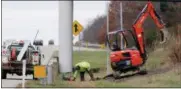  ?? JONATHAN TRESSLER — THE NEWS-HERALD ?? An ODOT employee works near the Interstate 90/ Vrooman Road interchang­e to install a permanent version of the new variable speed-limit signs.