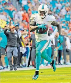  ?? CHARLES TRAINOR JR/MIAMI HERALD ?? Dolphins safety back Reshad Jones returns a fumble for a touchdown in the first quarter against the Titans on Sunday.