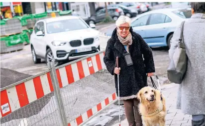  ?? FOTO: G. SALZBURG ?? Andrea Eberl mit ihrem speziell ausgebilde­ten Hund Annie auf der Rheydter Straße in Grevenbroi­ch. Die Corona-Maßnahmen stellen die blinde Frau oftmals vor Herausford­erungen.