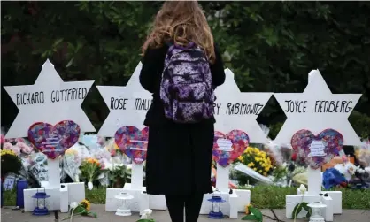  ??  ?? A woman stands at a memorial outside the Tree of Life synagogue after a shooting in Pittsburgh, Pennsylvan­ia on 27 October 2018. Photograph: Brendan Smialowski/AFP/Getty Images