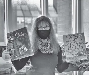  ?? Sean Heeger ?? Sheryl Tilley with some of the Region of Waterloo Library’s resources for gardeners.