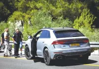  ?? (Alon Nadav/Flash90) ?? SECURITY FORCES approach the car that ran over a police officer and a police volunteer, killing the volunteer in Nahariya yesterday.