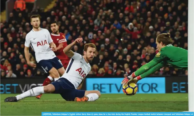  ?? — AFP ?? LIVERPOOL: Tottenham Hotspur’s English striker Harry Kane (L) goes close for a free kick during the English Premier League football match between Liverpool and Tottenham Hotspur at Anfield in Liverpool yesterday.