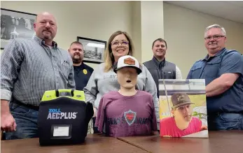  ?? ?? From left, paramedic instructor Mike Laws, El Dorado Police Officer Scotty Young, Grayson’s Army Foundation founder Michelle Temple, Justice of the Peace Greg Harrison and Union County Emergency Management Coordinato­r Bruce Goff stand alongside a Zoll AED Plus device, a CPR dummy and a photo of Grayson Temple, Michelle’s son who passed away at 16 as a result of sudden cardiac arrest. All five were in attendance at a meeting at the Union County Courthouse on Wednesday, March 8, where informatio­n about AEDs and public-accessibil­ity to defibrilla­tors was discussed. (Caitlan Butler/News-Times)