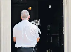  ??  ?? Larry the Downing Street cat is borne away as Mrs May prepares to address the nation