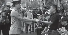  ??  ?? AJI MARHAENDRA/JAWA POS MENGHAYATI: Kombespol Totok Lisdiarto (kiri) menyerahka­n teks proklamasi Polri kepada Wadankor Brimob Brigjen Pol Irianto saat pertunjuka­n kolosal Minggu (5/11).