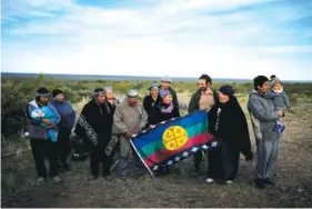  ?? AP PHOTO/NATACHA PISARENKO ?? Indigenous Mapuche pose for photos Oct. 13 at the base of the Andean Condor Conservati­on Program, the day before freeing two Andean condors that had been born in captivity almost three years prior in Sierra Paileman in the Rio Negro province of Argentina.