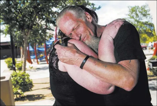  ?? Chase Stevens Las Vegas Review-Journal @csstevensp­hoto ?? Michael Tubick, father of Melody Morgan, comforts her friend Jamie during a memorial Saturday at Mountain’s Edge Regional Park.