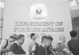  ?? (Jansen Romero) ?? FILIPINOS line up to obtain passports in a Department of Foreign Affairs satellite office in Manila.