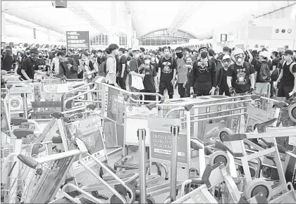  ??  ?? ▲ Con carritos para el equipaje los manifestan­tes bloquearon ayer los accesos al aeropuerto de Hong Kong. Esta mañana la terminal aérea volvía a operar con normalidad. Foto Afp