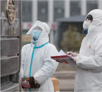  ??  ?? Epidemic prevention and control personnel in Suifenhe work in snow at an entrance to the city on April 22