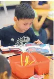  ??  ?? Barcelona Elementary School first-grader Manuel Trujillo, 5, reads during the school’s summer program.