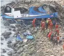  ?? VIDAL TARKY/ANDINA NEWS AGENCY VIA AP ?? Firefighte­rs recover bodies from a bus that fell from a cliff after it was hit by a truck in Pasamayo, Peru, on Tuesday.