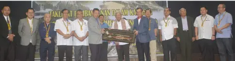  ??  ?? Masing (centre) receives a memento from Ismawi (on his left) and Kapit Resident Joseph Belayong, witnessed by (from third right) Blikau, Aaron and Ugak, Jamit (fourth left), Nyabong, (fifth left) and others.