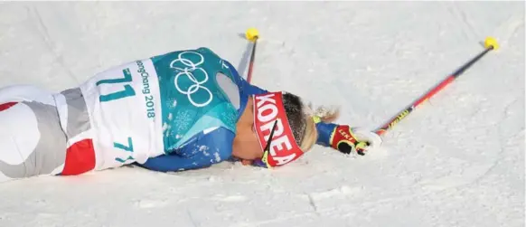  ?? STEVE RUSSELL/TORONTO STAR ?? South Korean crowd favourite Magnus Kim collapses at the finish line after finishing 45th in the men’s 15-kilometre freestyle race Friday. Switzerlan­d’s Dario Cologna won the race.