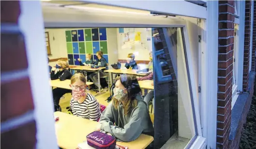  ?? BILD: Gregor Fischer ?? Nur Lüften reicht nicht gegen das Coronaviru­s: Schüler einer sechsten Klasse lernen bei gekippten Fenstern. In Niedersach­sen soll es bald mehr Geld für weitere Schutzmaßn­ahmen geben.