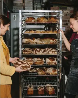  ??  ?? Clockwise from left: Cherry Moon’s head baker and owner Kimmy Gastmeier (left) with the morning sourdough bake; sourdough rosemary focaccia. Opposite: sourdough loaves are kept in bannetons overnight in the coolroom before baking to slow down the fermentati­on and develop flavour.