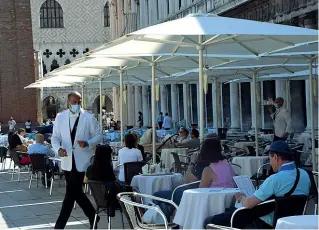  ??  ?? In piazza
I sessanta ombrelloni aperti dai bar di piazza San Marco. A destra, il quadro del Canaletto